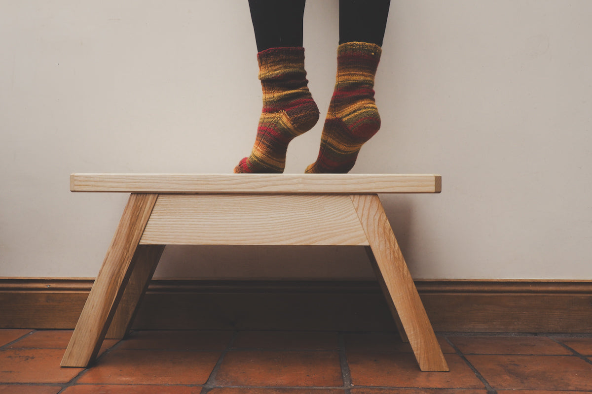 Northumberland stool with a pair of legs standing on it