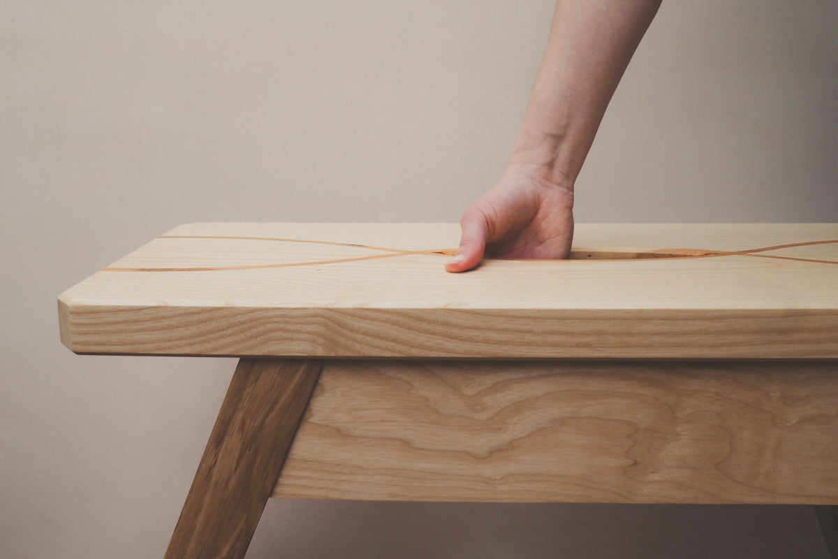 A hand can be seen going into the hand holder on the top of the stool