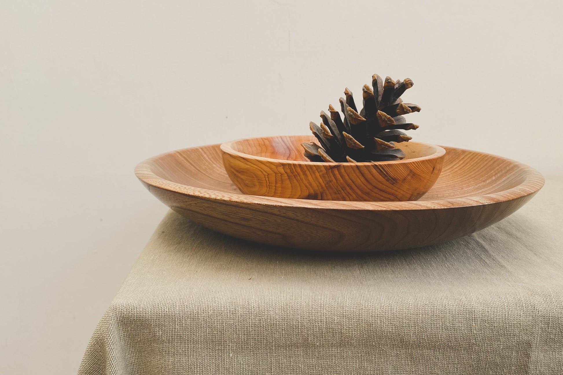 Medium sized wooden bowl with a smaller sized wooden bowl inside.